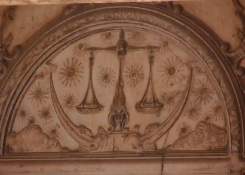 Cross in the form of scales on top of horns